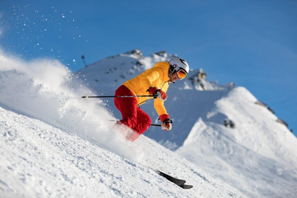 Skieur qui descend la pente beau temps belle neige chaussures de ski confortables