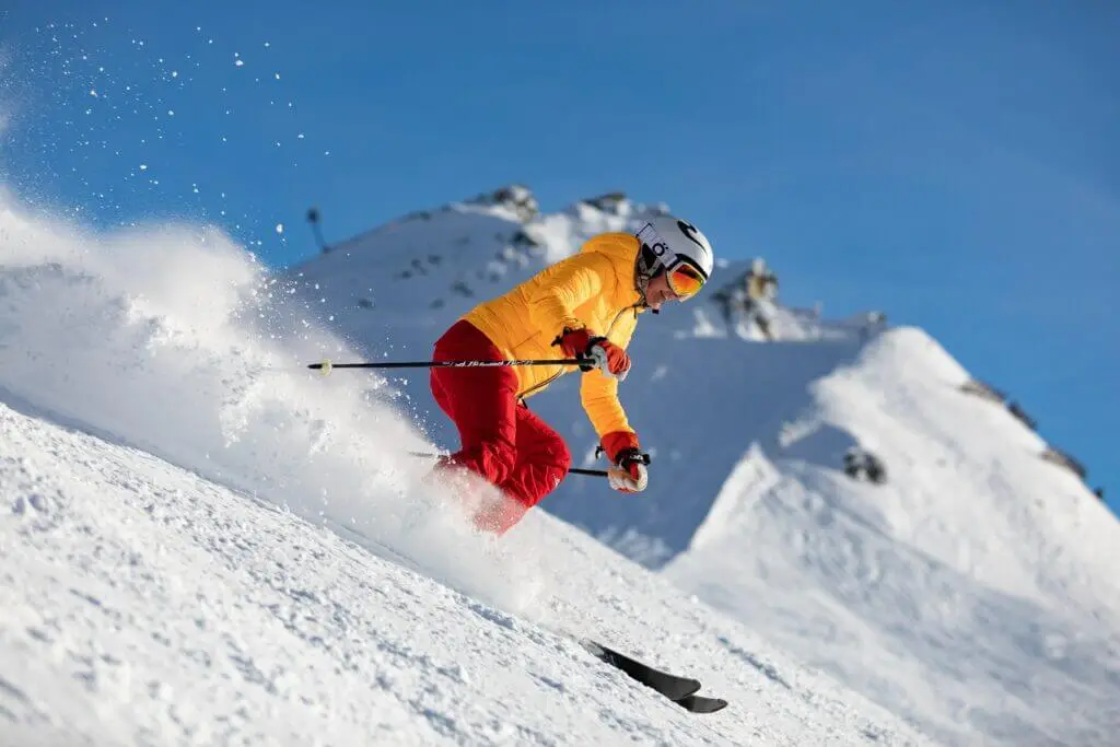 Skieur qui descend la pente beau temps belle neige